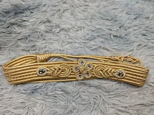 Detailaufnahme eines luxuriösen goldenen Flechtgürtels mit Strassblumen und Kristallen