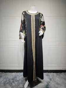Detailed view of black Abaya dress with elegant gold sequin embroidery and floral patterns.