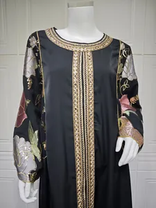 Detail view of black dress featuring intricate gold and floral sequin embroidery