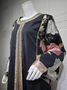 Detailed view of black abaya featuring elegant sequin floral embroidery and gold trim