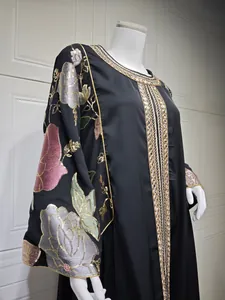 Detail of black Abaya dress with elegant gold sequined floral embroidery on sleeves.