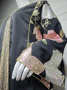 Macro view of exquisite pink and gold sequin floral embroidery on black satin dress