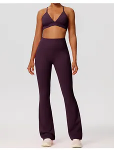 Detail van een dieppaarse yogaset met een sportbeha en een uitlopende legging met taille.