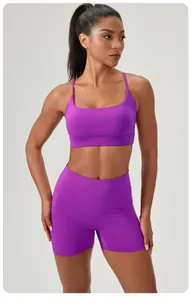 Vibrant purple two-piece yoga set featuring a sports bra and high-waisted shorts on a fitness model
