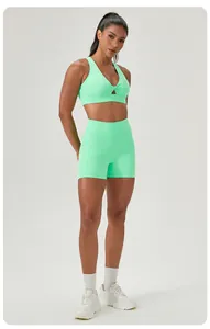 Detail view of mint green twist front sports bra and high waisted yoga shorts on model