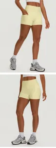 Detail view of high waisted yellow yoga shorts with side pockets for women sports.