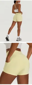 Close-up of yellow high-waisted yoga shorts with side pockets and lifting design.