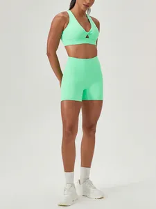 Two-piece mint green yoga set featuring twist front bra and high waist gym shorts