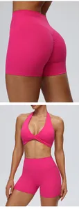 Gedetailleerde weergave van roze yoga shorts met hoge taille en halter sportbeha set.