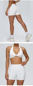 Detailweergave van een witte yogaset met korte broek met hoge taille en halter sportbh.