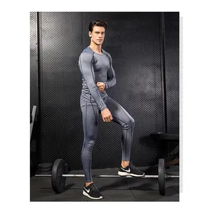 Male model in a gym wearing a grey compression fitness set with long sleeve and pants