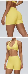 Detailweergave van de gele yoga shorts en bijpassende halter sportbeha voor dames