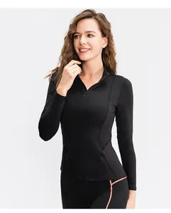 Detailweergave van de zwarte sporttop met lange mouwen en halve rits voor damesyoga