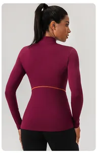 Achteraanzicht van slim fit bordeauxrode yoga-top met een oranje taille-detaillijn