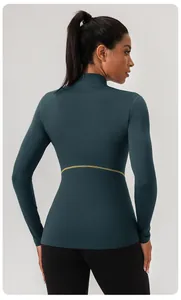 Achteraanzicht van een nauwsluitende groenblauwe yoga top met lange mouwen en taille-detail
