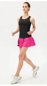 Vista lateral de modelo con falda-pantalón deportiva magenta y camiseta de tirantes