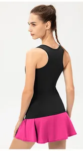 Vista trasera de una mujer con top deportivo negro y falda pantalón rosa vibrante