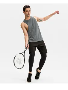 Male model wearing a grey loose sports tank top and black shorts while holding a tennis racket