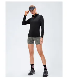 Full-body view of a model wearing a black quarter-zip slim fit long sleeve sports top.