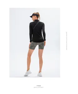 Back view of an athletic woman in black long-sleeve sports top and camouflage shorts