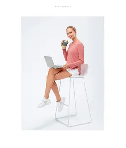 Modèle en tee-shirt rose à manches longues avec protection solaire UPF 50+ assise.