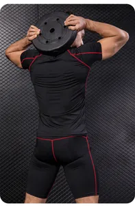 Achteraanzicht van zwarte compressieset voor heren met rode stiksels voor fitnesstraining.