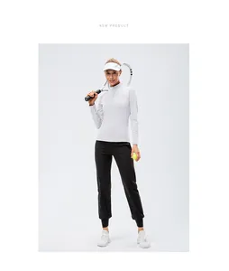 Athletic woman in slim fit white sports sweatshirt and black joggers holding tennis racket