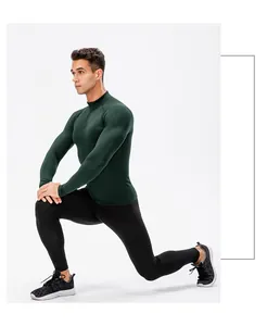 Donkergroen thermisch compressieshirt voor heren getoond in een sportieve uitvalspas-pose.