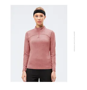 Detailed view of pink heathered half-zip athletic top on model against white background.