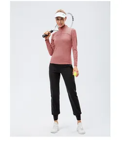 Professional women's tennis wear with pink long-sleeved top and black joggers