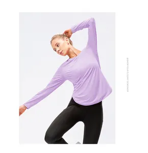 Modèle portant un haut de yoga violet à manches longues avec protection UPF50 pour sport