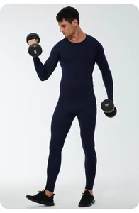 Full body shot of a man wearing navy blue thermal compression sports set holding dumbbells