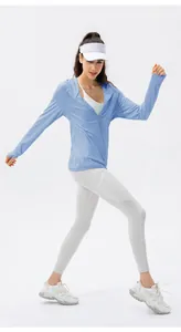 Vue complète d'une femme avec veste de protection solaire bleu clair respirante et visière.