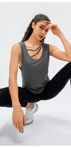 Detail of grey loose yoga tank top with unique asymmetric neck straps for women.