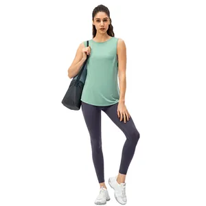 Full-length view of a woman wearing a mint green yoga tank top and dark grey leggings.
