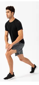 Vista detallada de hombre haciendo estocadas con pantalones cortos deportivos grises