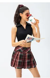Professional shot of a model wearing a plaid pleated tennis skort with a black crop top