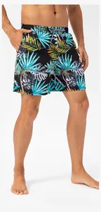 Detail view of men's quick-dry beach shorts with vibrant tropical palm leaf print