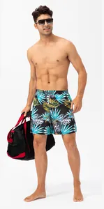 Men's quick-dry tropical leaf print swim shorts shown on model in studio setting.