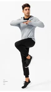 Volledig aanzicht van een mannelijk model in zwarte joggingbroek en grijze sportjas