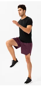 Detalle de un hombre con pantalones cortos deportivos morados y camiseta negra al correr