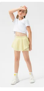 Ολόσωμη άποψη κοριτσιού με λευκό crop top και κίτρινη φούστα τένις για σπορ