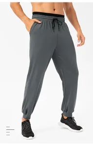 Detailopname van grijze herenjoggers met elastische tailleband en verstelbaar trekkoord.