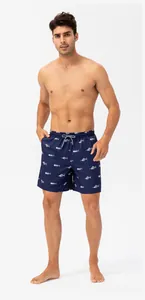 Full body shot of a male model wearing navy blue quick-drying beach shorts with fishbone pattern.
