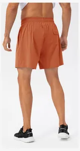 Back view of orange quick-dry sports shorts with elastic waist and pocket detail.