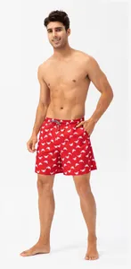 Full body shot of red men's swim trunks with white crab print on a plain white background.