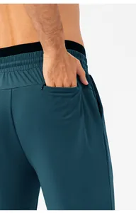 Detail van een sneldrogende sportbroek voor heren met een functionele achterzak met rits.