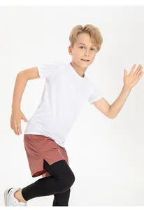 Scatto d'azione di un ragazzo in maglia bianca traspirante e pantaloncini sportivi