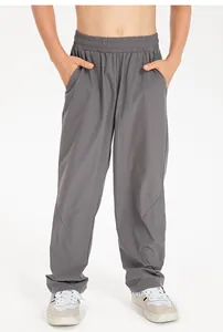 Macro detail of kids' grey loose sports trousers showing waist elastic and fabric texture