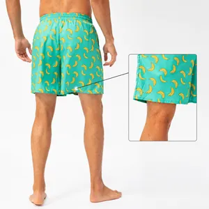 Men's teal fast-dry beach shorts featuring a vibrant yellow banana print pattern